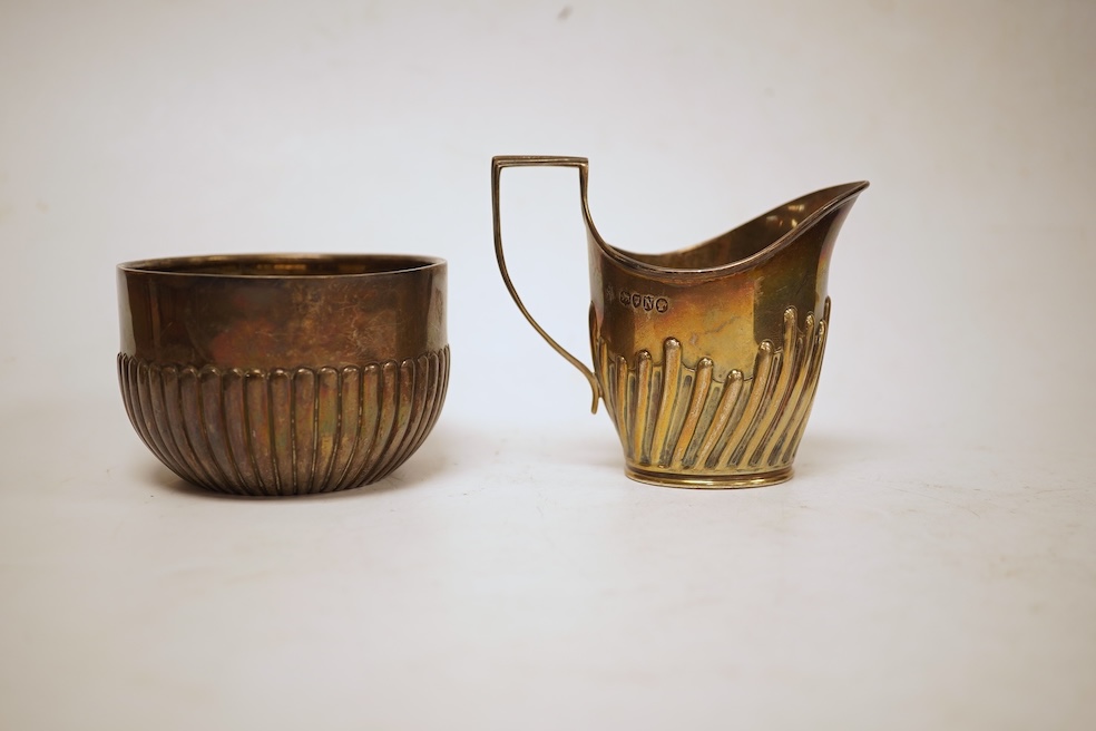 A late Victorian demi-fluted cream jug and sugar bowl, Charles Stuart Harris, London, 1888, together with cased silver christening egg cup, spoon and napkin ring and two other silver napkin rings.